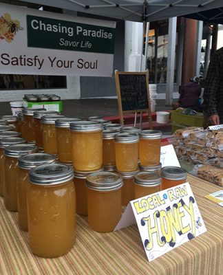 Jars of Chasing Paradise local raw honey at the market